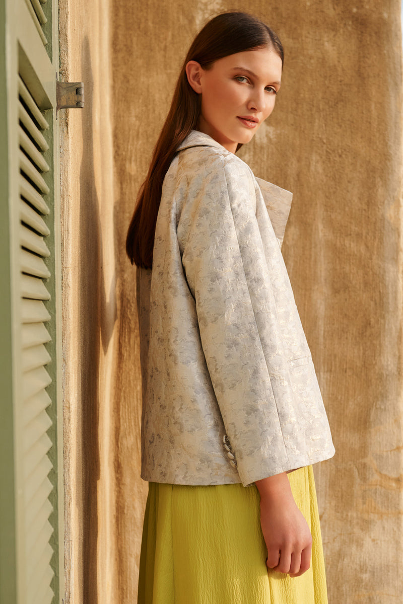 Wiggy Kit | The Mercer Jacket | Model wearing white patterned occasion jacket with yellow dress