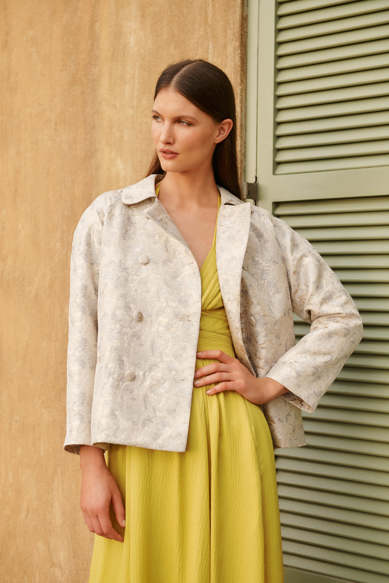 Wiggy Kit | The Mercer Jacket | Model wearing white patterned occasion jacket with yellow dress