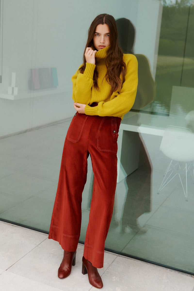 Wiggy Kit | Waffle Turtleneck in Yellow | Model Wearing Yellow Jumper and Red Jeans