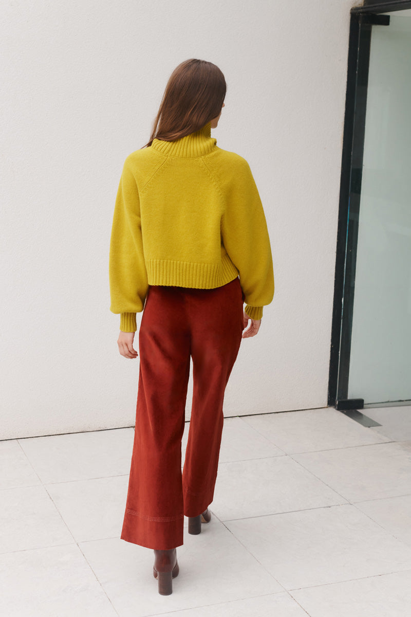 Wiggy Kit | Waffle Turtleneck in Yellow | Model Wearing Yellow Jumper and Red Jeans