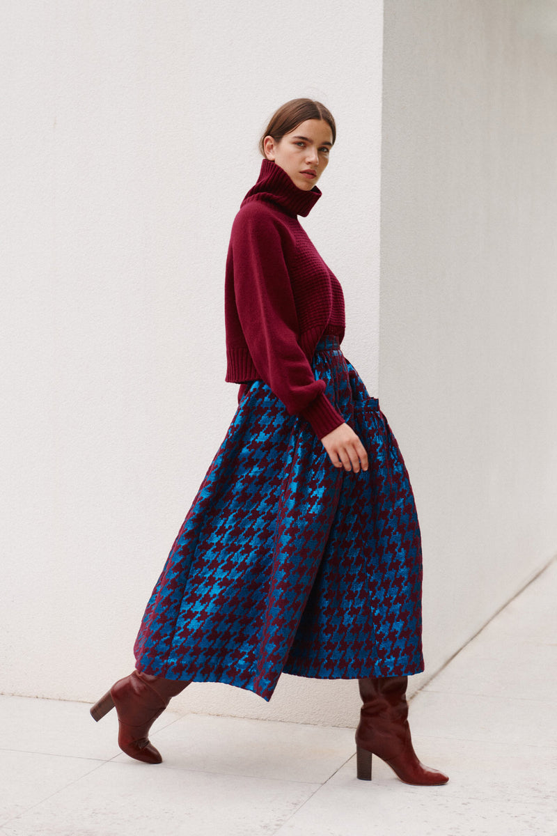 Wiggy Kit | Waffle Turtleneck in Dark Red | Model Wearing Dark Red Jumper and Patterned Skirt