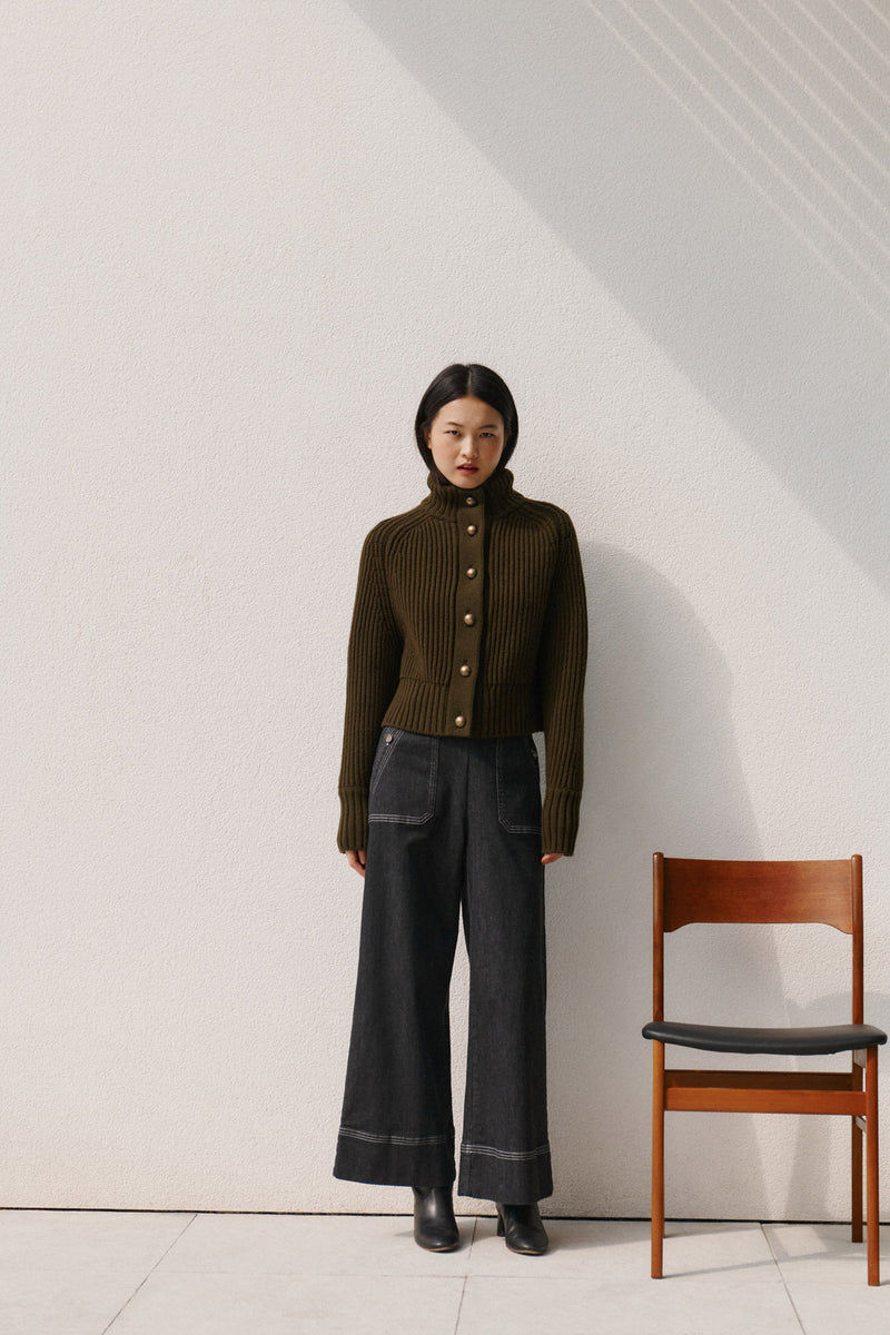 Wiggy Kit | Ribbed High Neck Jacket in Green | Model Wearing Ribbed High Neck Jacket with Jeans