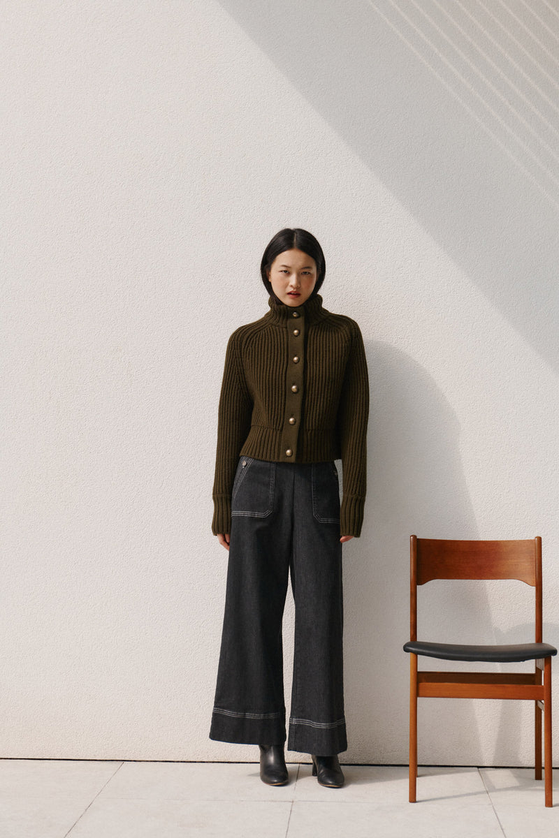 Wiggy Kit | Ribbed High Neck Jacket in Green | Model Wearing Ribbed High Neck Jacket with Jeans