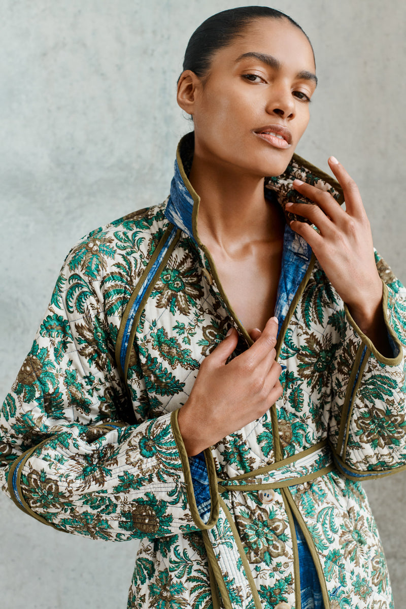 Wiggy Kit | Quilted Raglan Coat | Close up of model wearing long floral reversible coat with blue dress underneath