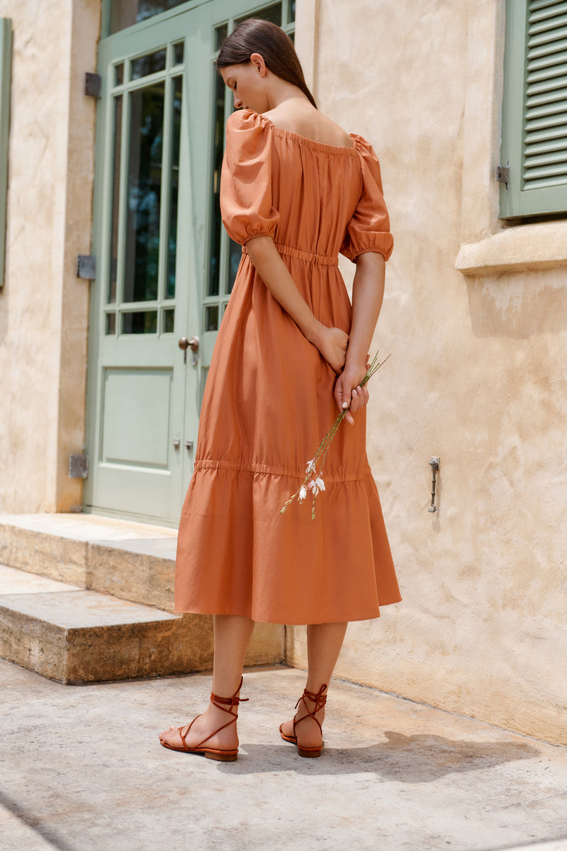 Wiggy Kit | The Toto Dress | Model wearing rusty orange midi dress with puffy sleeves