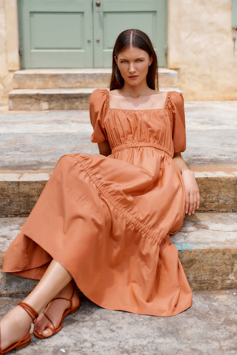 Wiggy Kit | The Toto Dress | Model wearing rusty orange midi dress with puffy sleeves